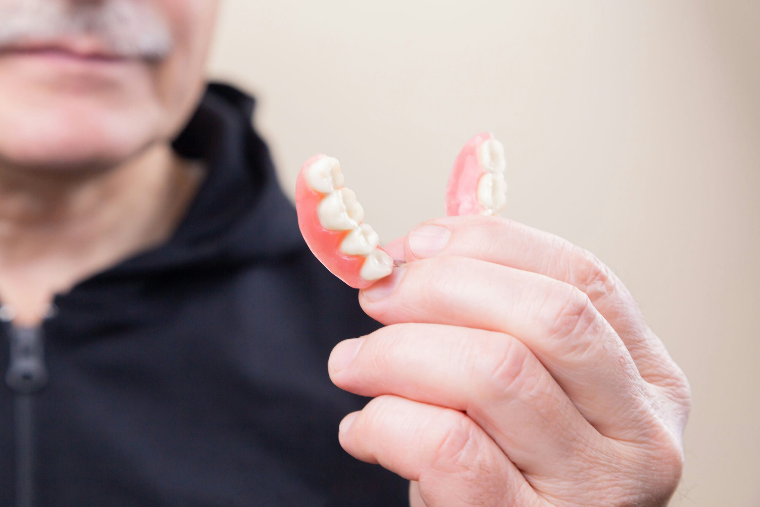 Person holding Dentures